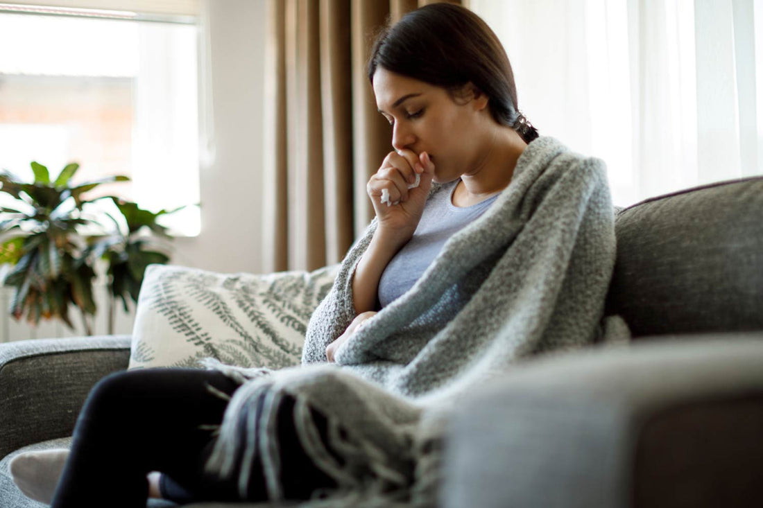 Woman on cough covering cough with hand