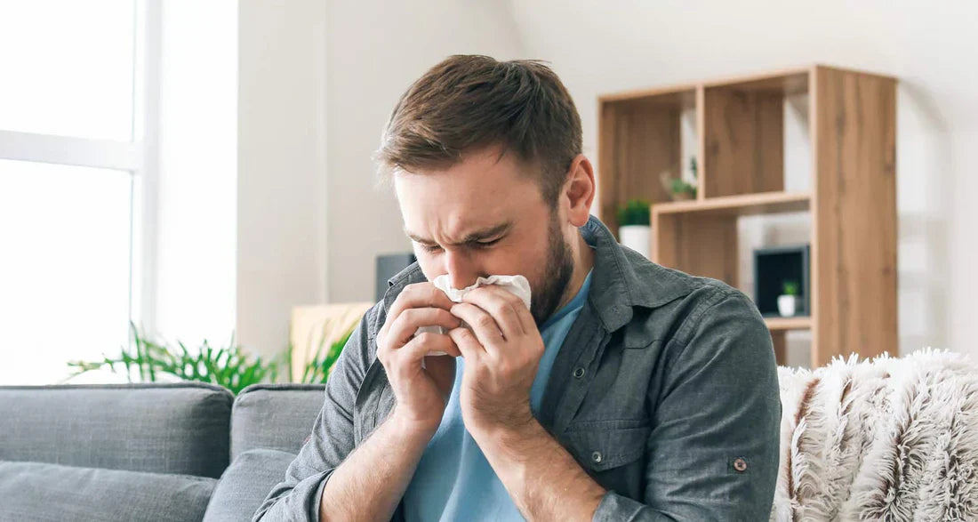A Man sitting on cough dealing with congestion.
