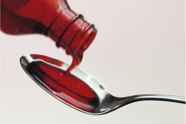 cough_liquid_being_poured_onto_spoon.webp