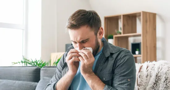 A man sitting on the cough dealing with congestion