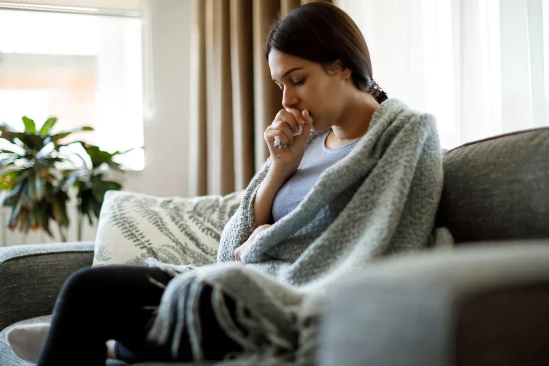 A women on cough covering cough with hand