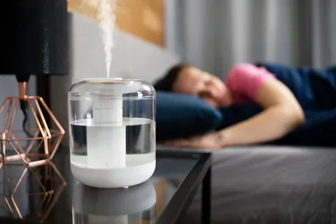 A_man_laying_in_bed_with_a_humidifier_on_the_nightstand_480x480.webp